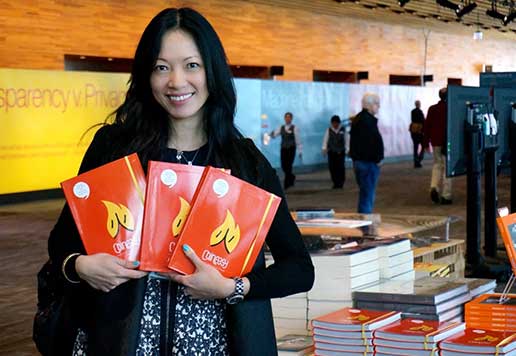 A woman proudly displays the books she launched on Kickstarter
